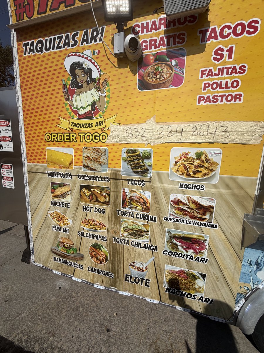 A close-up of Taquizas Ari's painted menu board with photos of tacos, tortas, and more