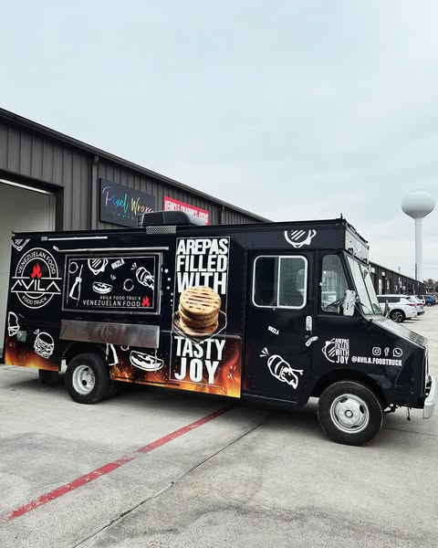 The black Avila food truck parked outside the wrap shop