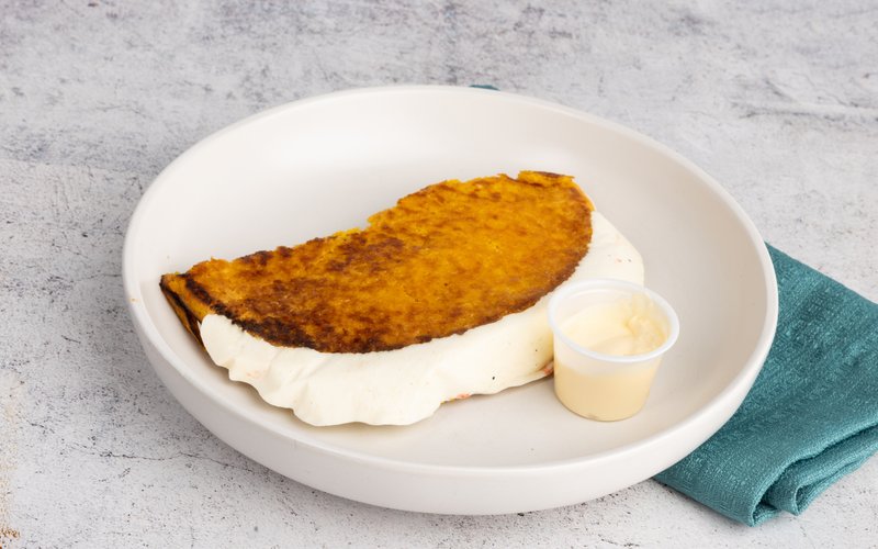 A golden corn cachapa folded around white cheese