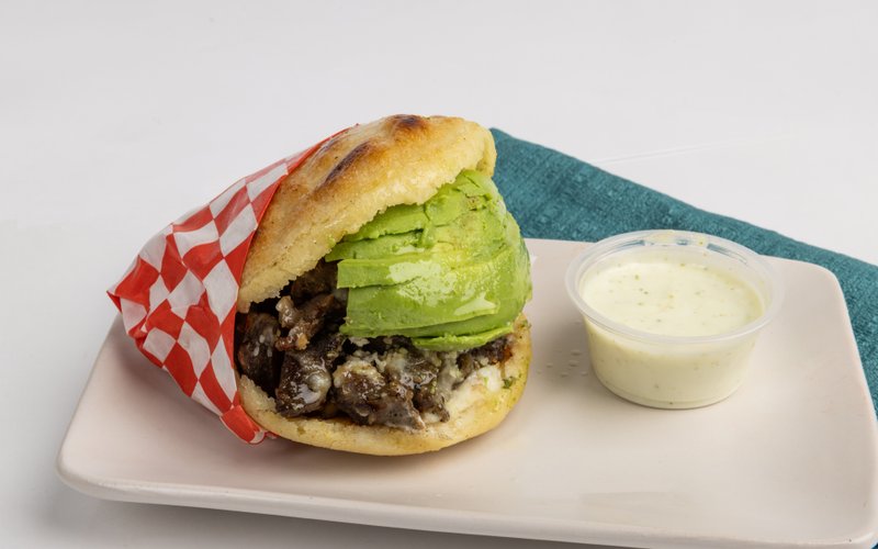 An Avila arepa filled with avocado, meat, and cheese