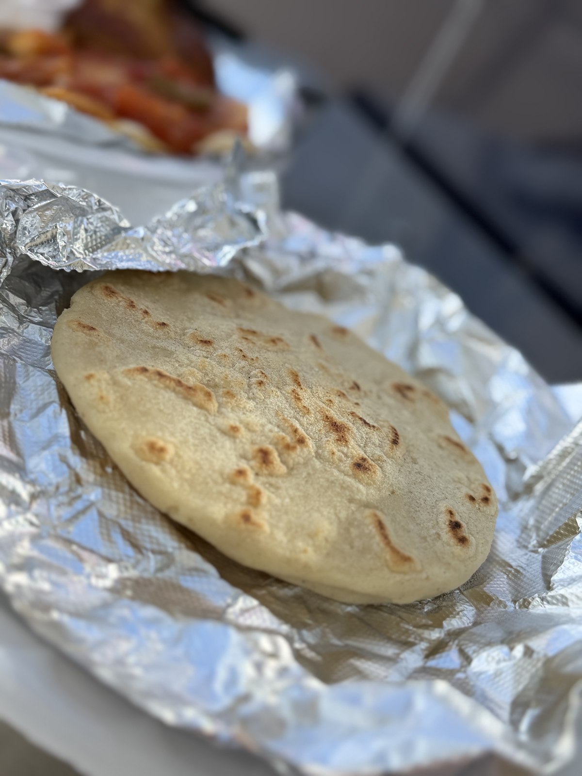 A close-up of a griddled pupusa fresh off the flat top