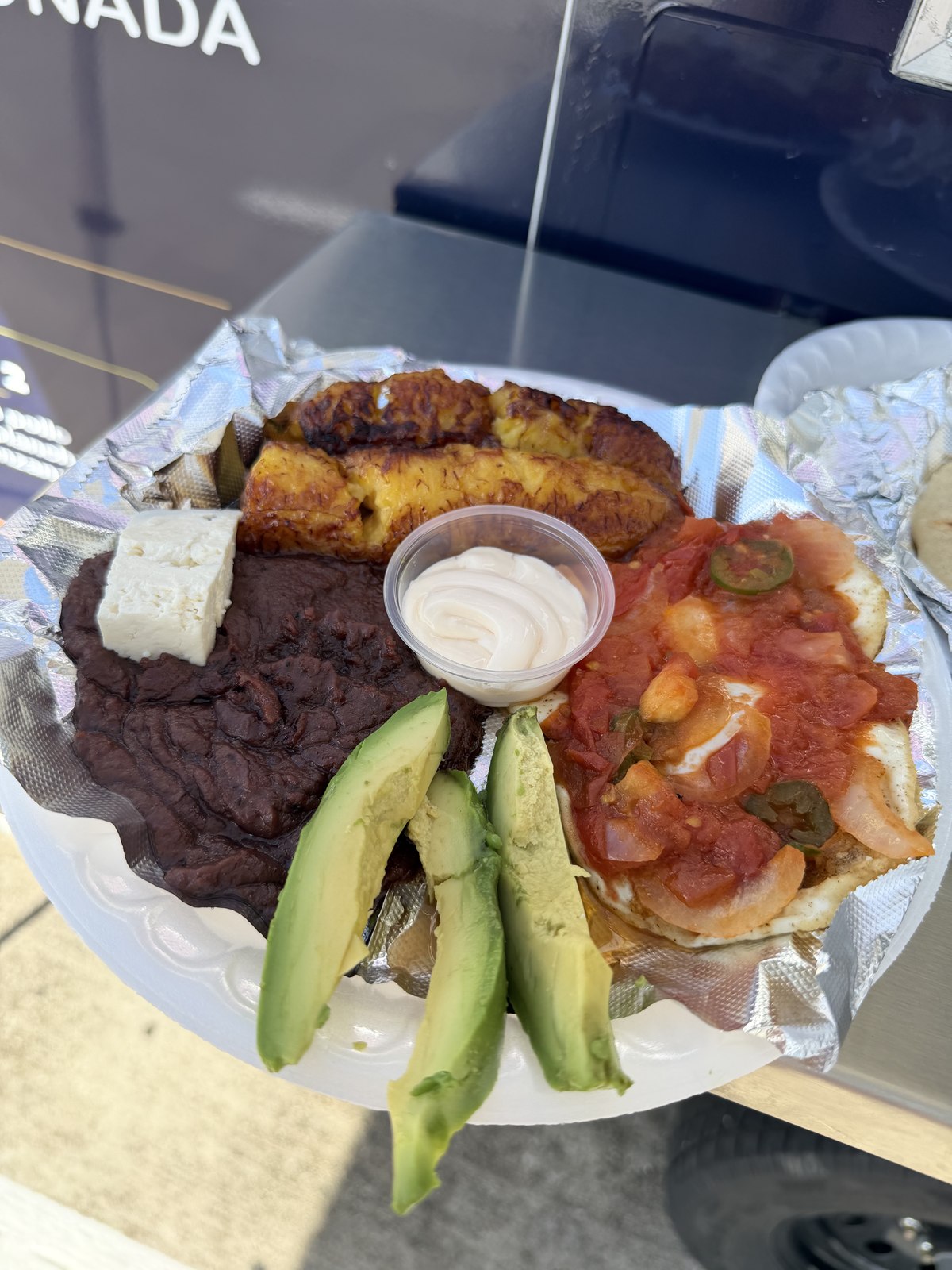 A Desayuno Salvadoreño plate with eggs, fried plantains, beans, cheese, and avocado