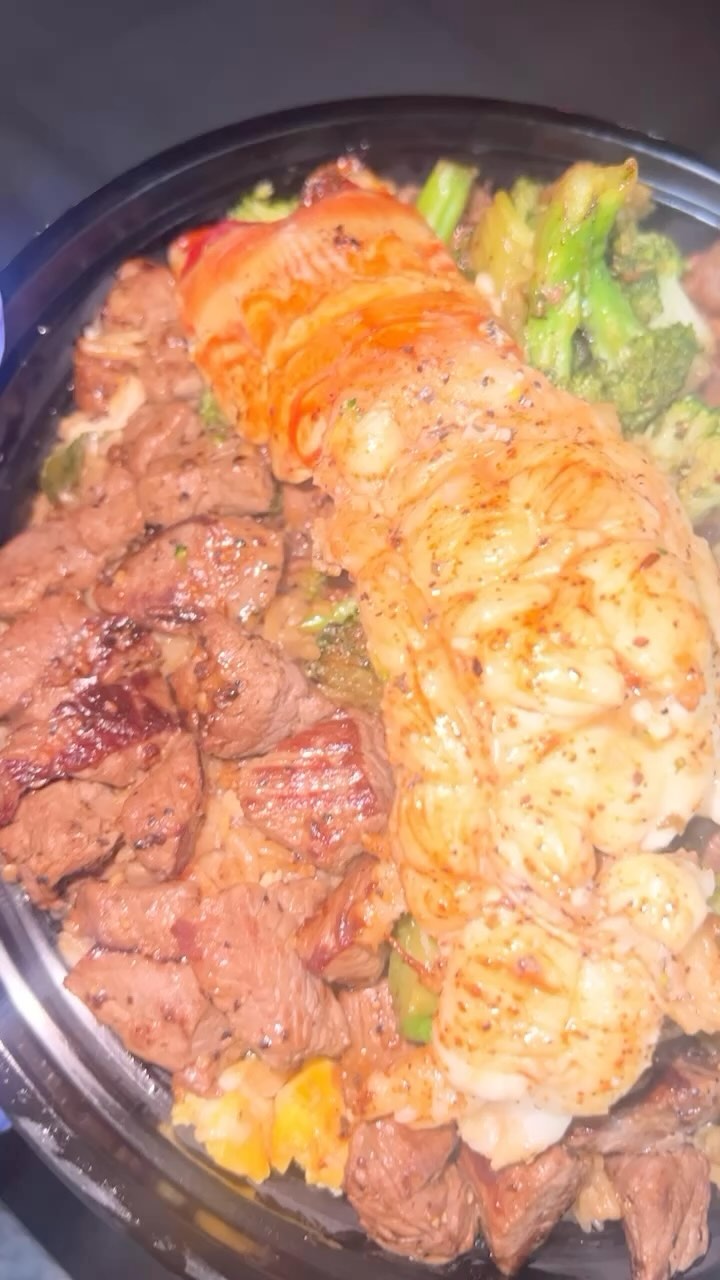 A lobster tail with steak, shrimp and broccoli
